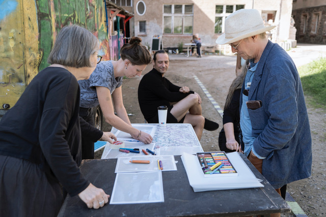 Rückblick. 4 Teilnehmer planen an einem Tisch.
